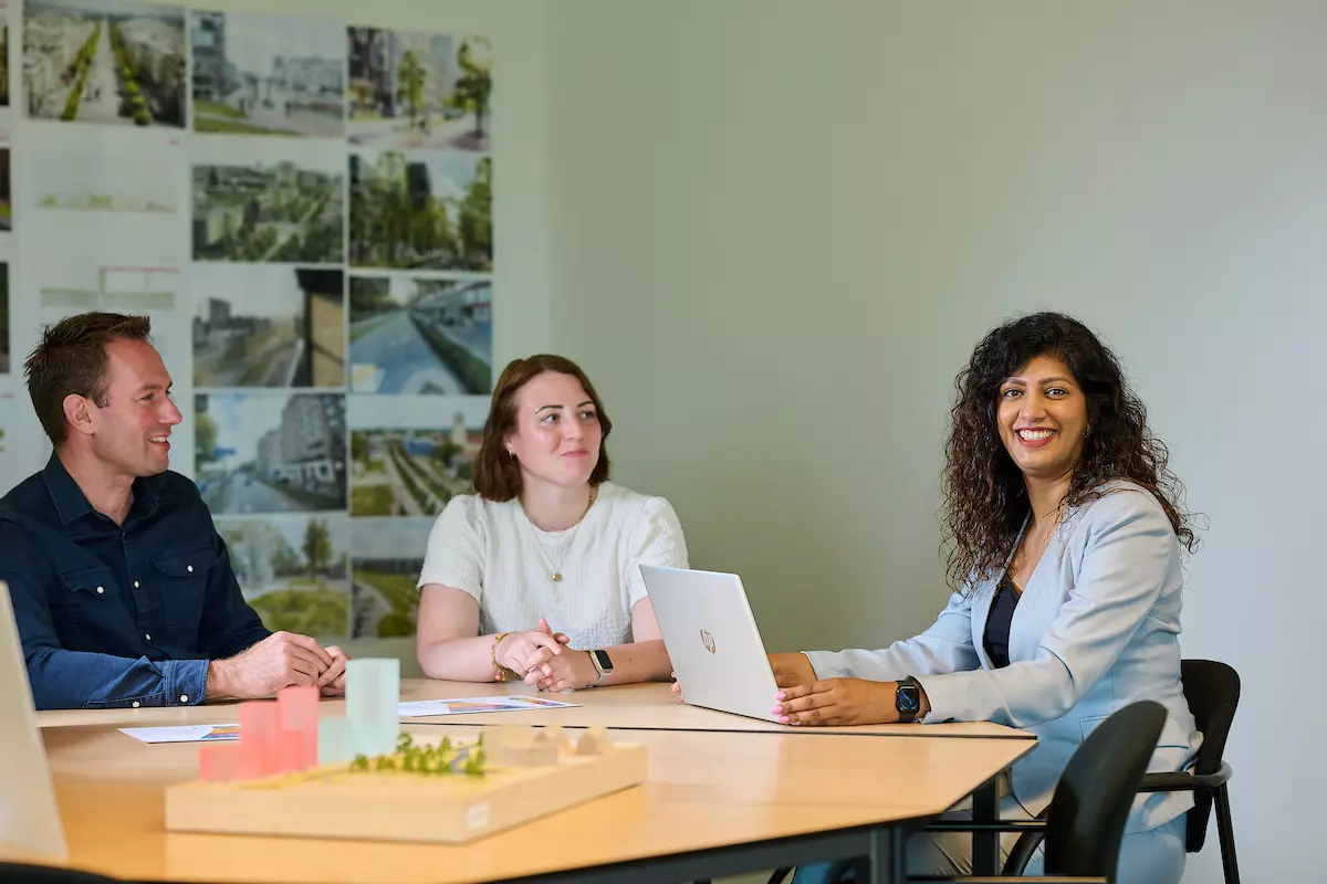 Drie collega's in overleg aan een vergadertafel binnen de afdeling Financiën en Control.