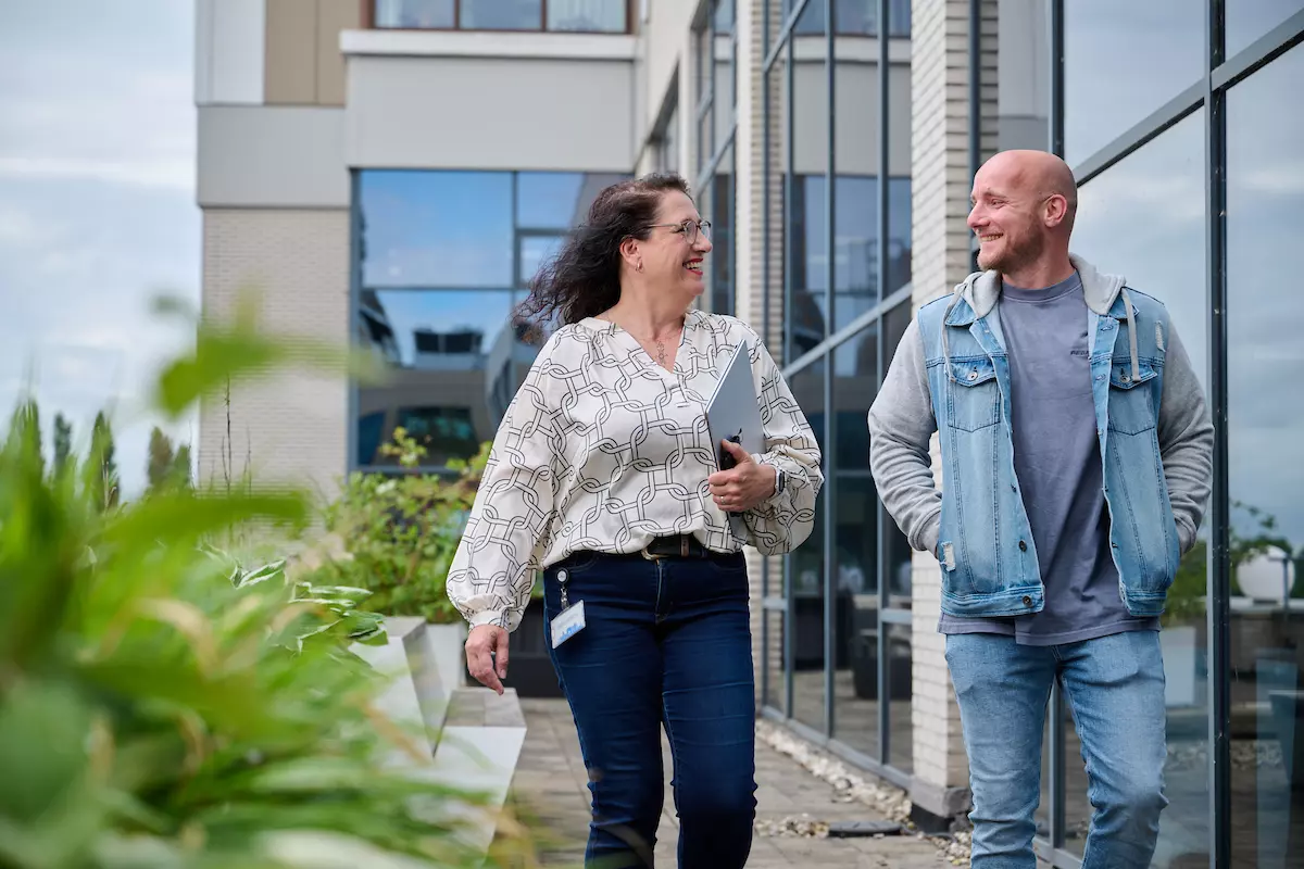 Twee collega's lopen over het balkon.