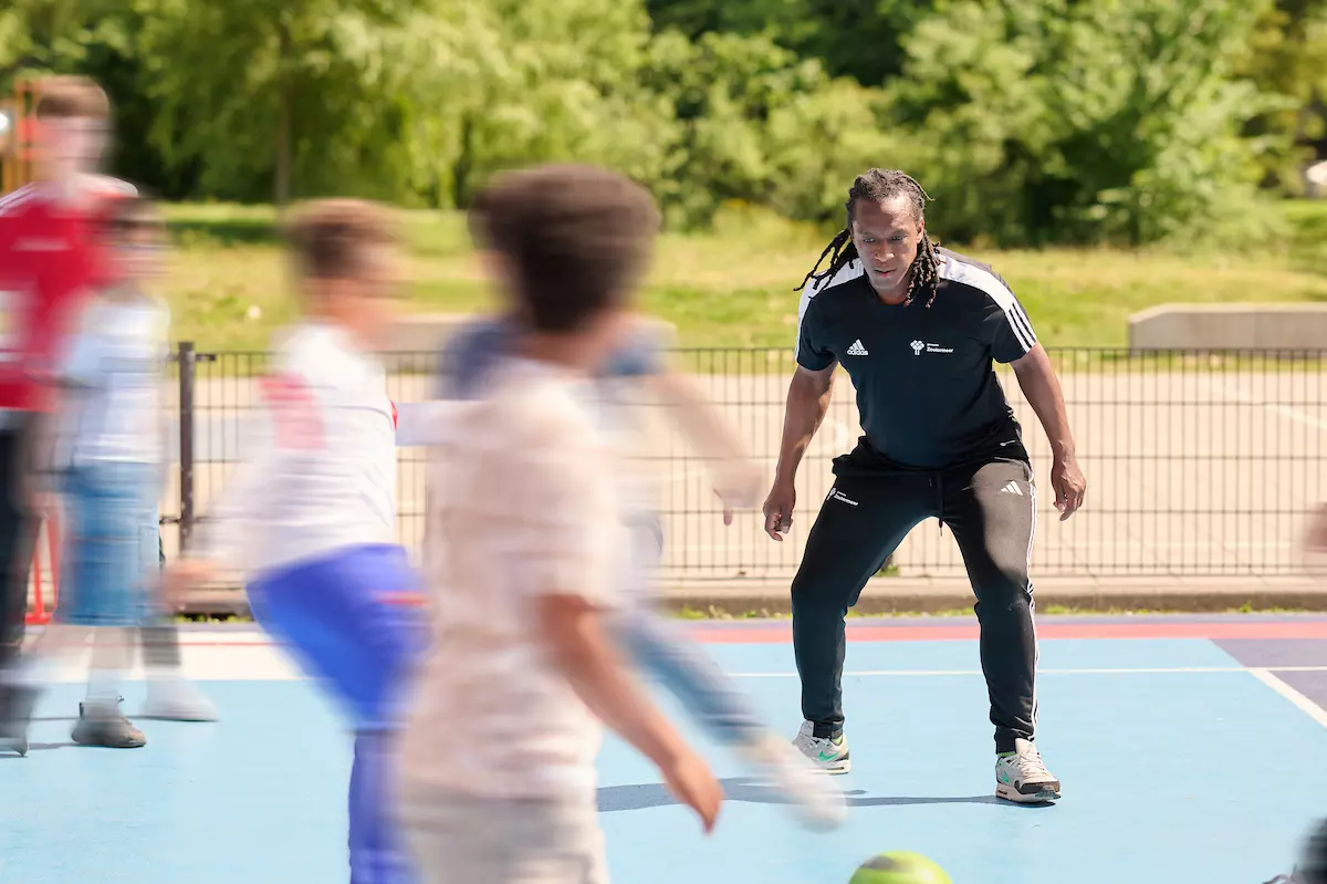 Man met bal bij schoolplein
